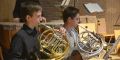 Zwei Jugendliche spielen Horn im Orchester