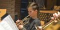 Junge im Orchester spielt Trompete